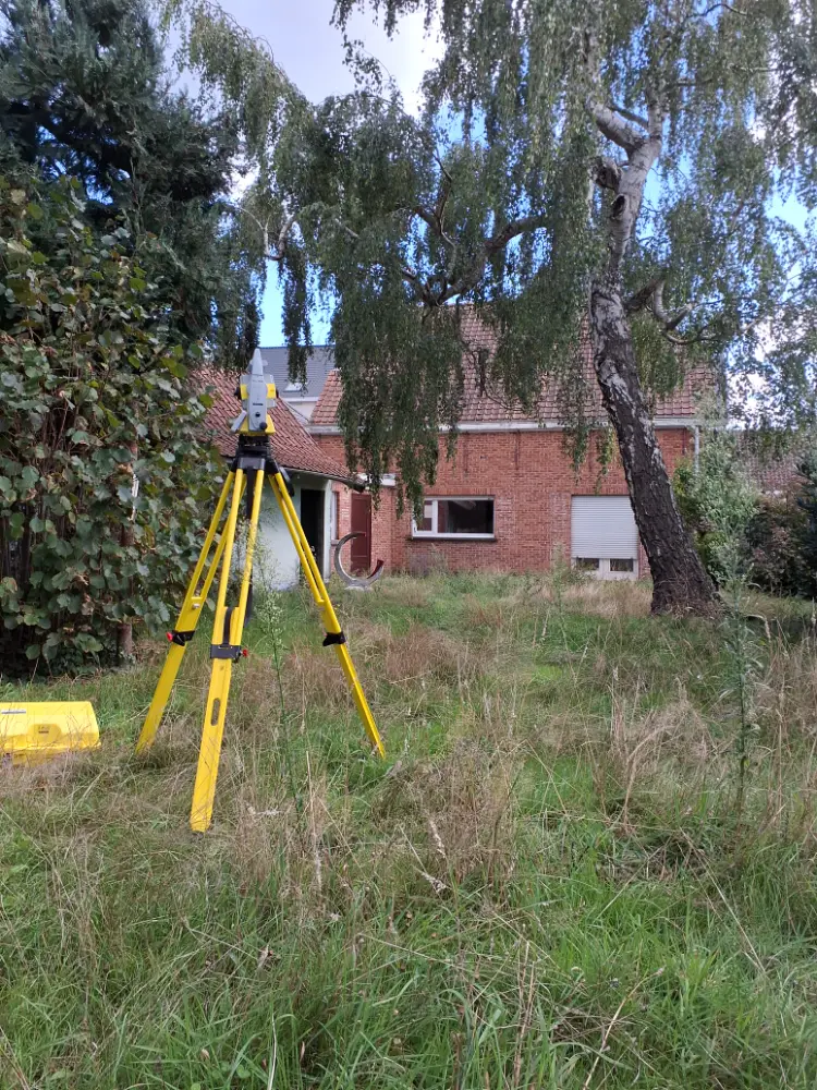 Totaalstation opgesteld in een tuin bij een woning voor een afpaling