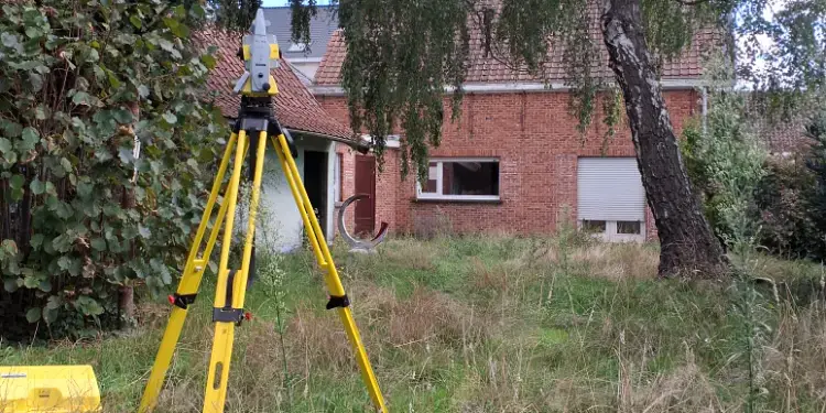 Totaalstation opgesteld in een tuin bij een woning voor een afpaling